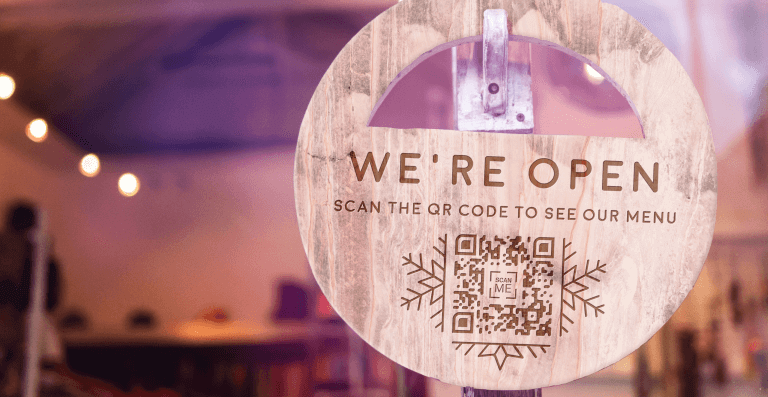 A wood QR Code menu displayed on the door handle at Cozy Cafe.