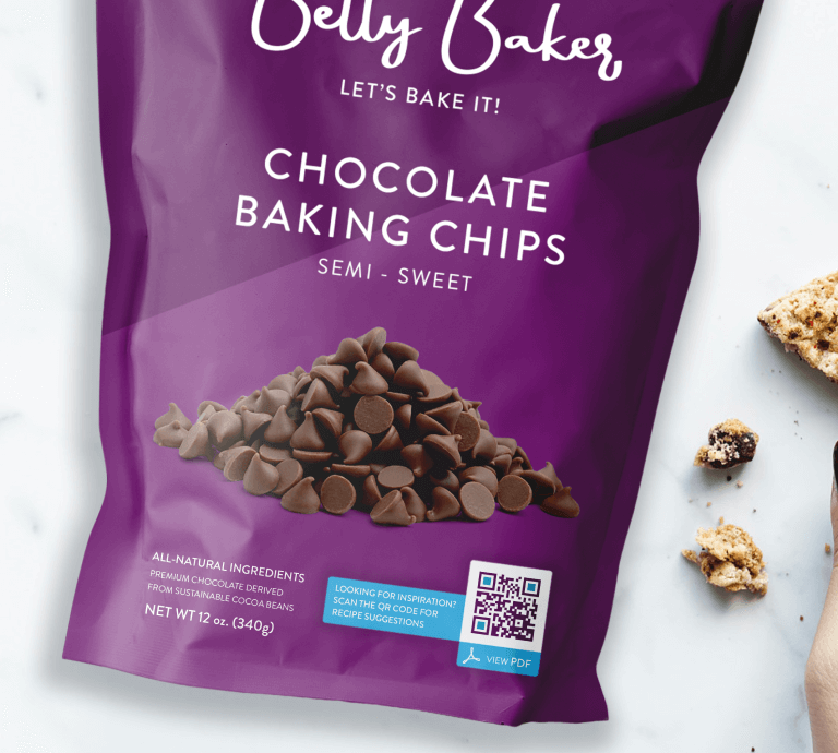 A person holding a chocolate chip cookie next to Betty Bakes’s purple product packaging.