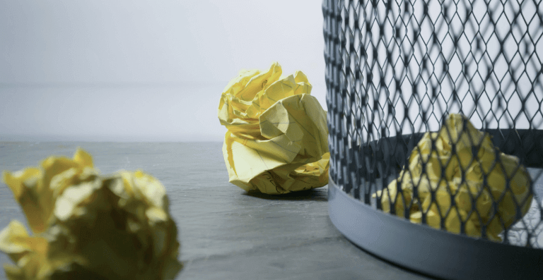 Waste paper next to a trashcan