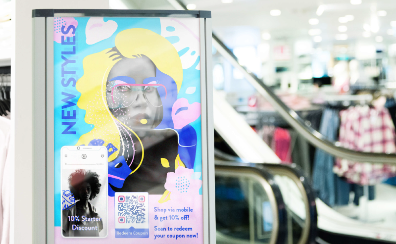 Coupon QR Code on a fashion brand's poster ad prompting people to scan and redeem a 10% off coupon