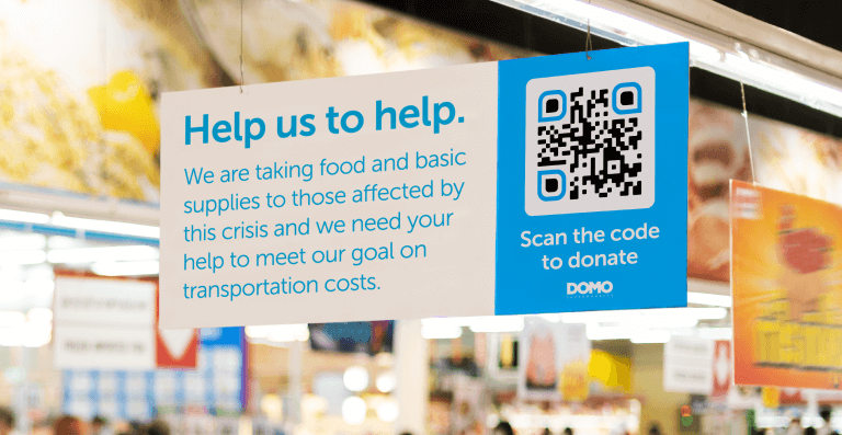 A QR Code on a sign collecting donations to cover transportation costs for humanitarian aid.