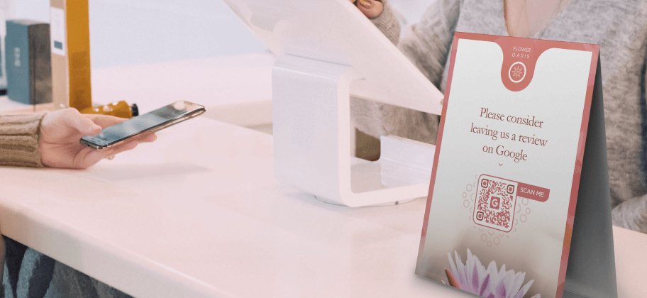 The front desk of a wellness center hosts a large advertisement for customers to leave a Google review with a QR Code.
