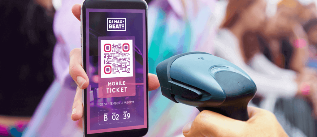: A festival goer presents a QR Code mobile ticket while someone scans it using a scanner.
