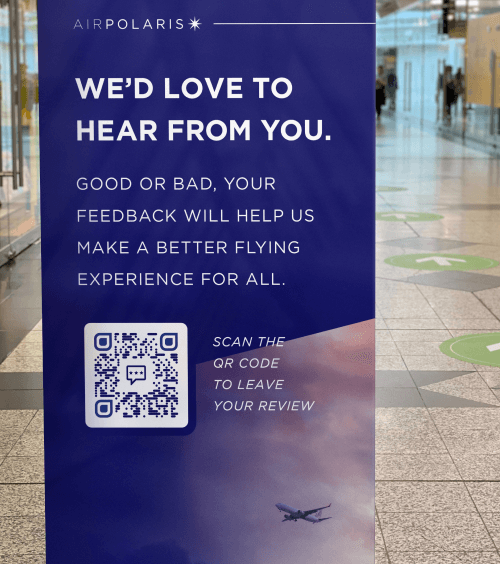 QR Code on an airline's banner display prompting people to scann to leave a flight review.