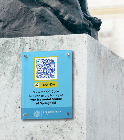 A sign on a monument in a city with a QR Code that contains an audio guide of the city’s history.