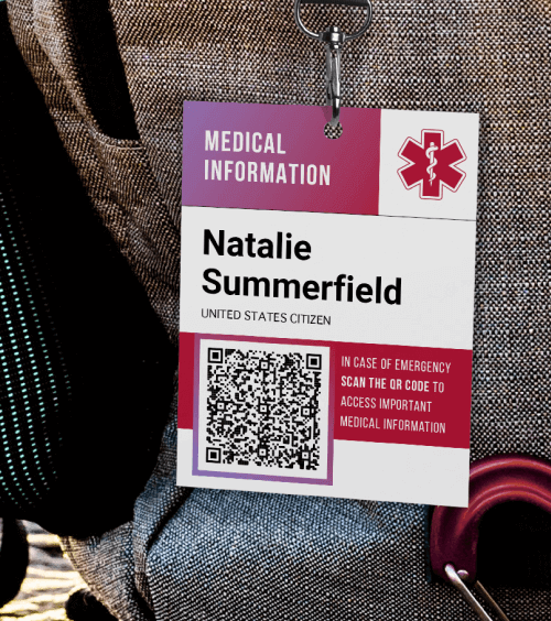 Travel backpack on a mountain ridge including a tag with information about the traveller including a QR Code with a “Scan me” frame