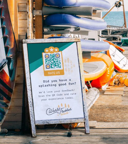 An A-board at a paddleboarding booking office with a QR Code that asks customers to rate their experience