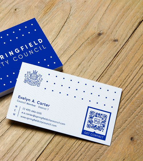A business card of a city council member with a QR Code that contains contact details.