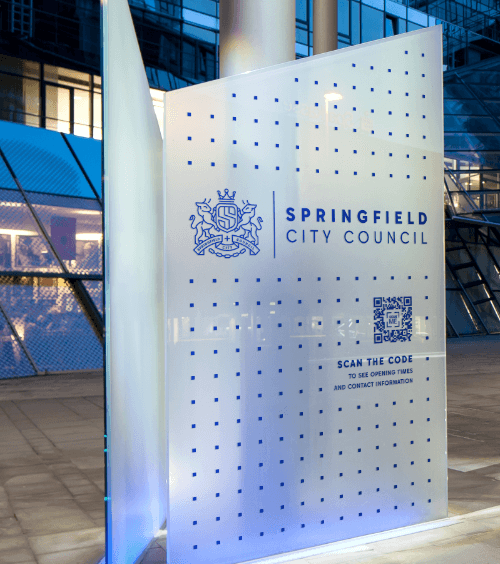 A signage outside of a government office with a QR Code that contains business information when scanned.