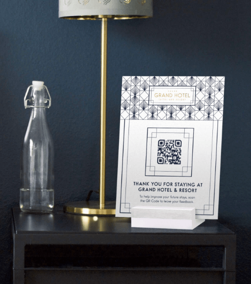 A table tent in a hotel room with a QR Code that redirects hotel guests to a feedback form.