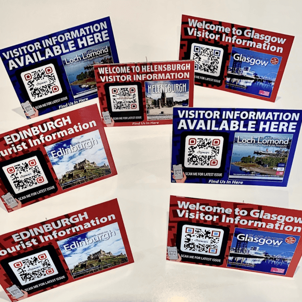 QR Codes on visitor information table tent displays prompting people to scan for the latest issue of tourist information.